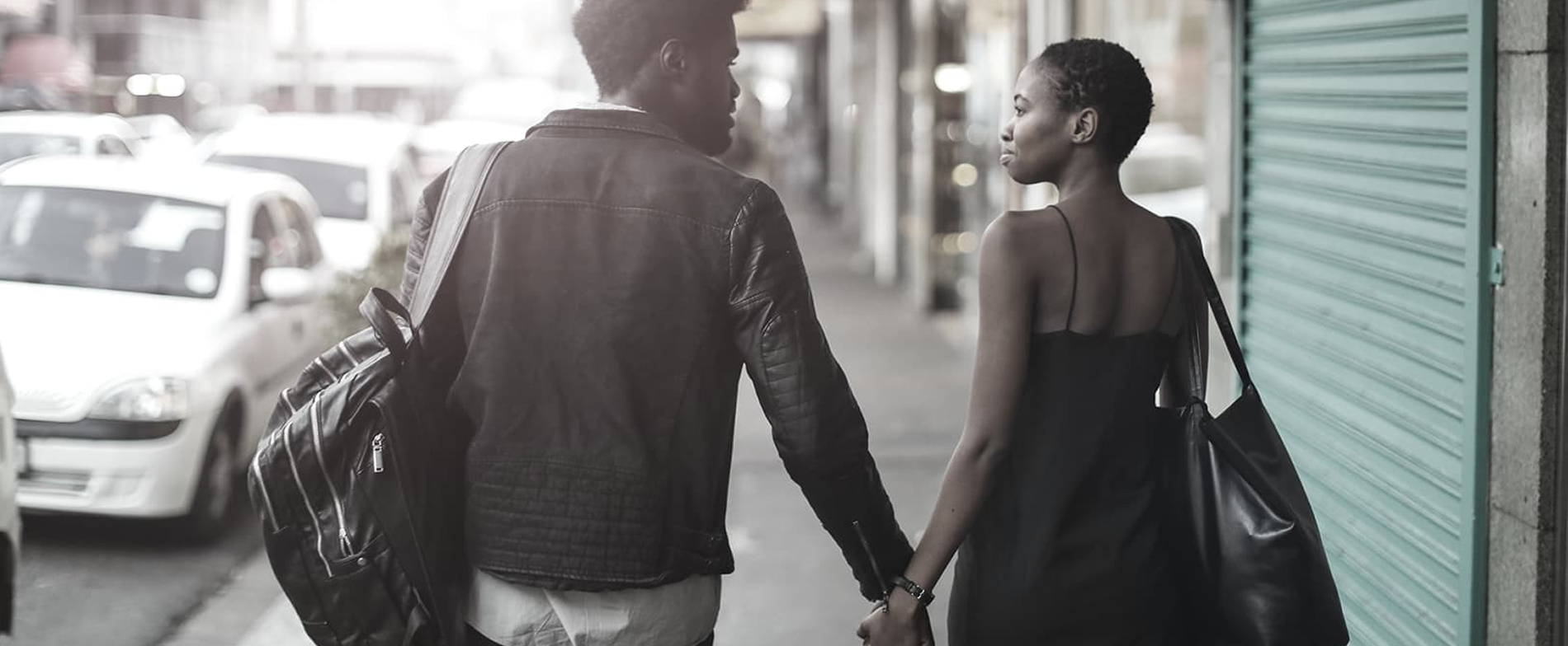 Pareja caminando de la mano por una calle de la ciudad